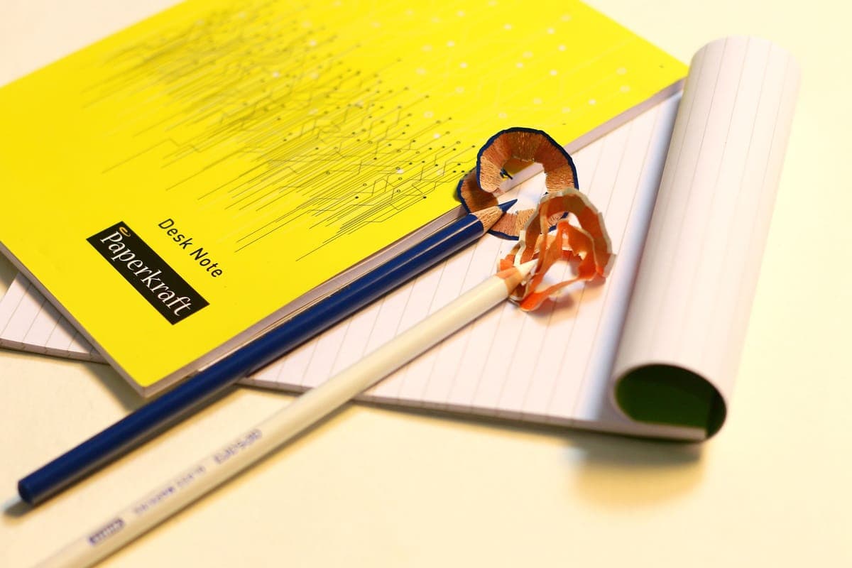 A notebook and sharpened pencils arranged on a desk