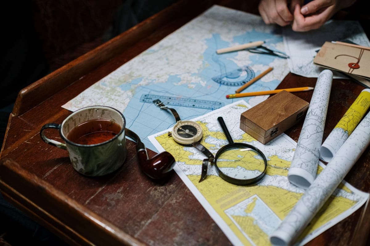 A paper map and a compass laid out on a table