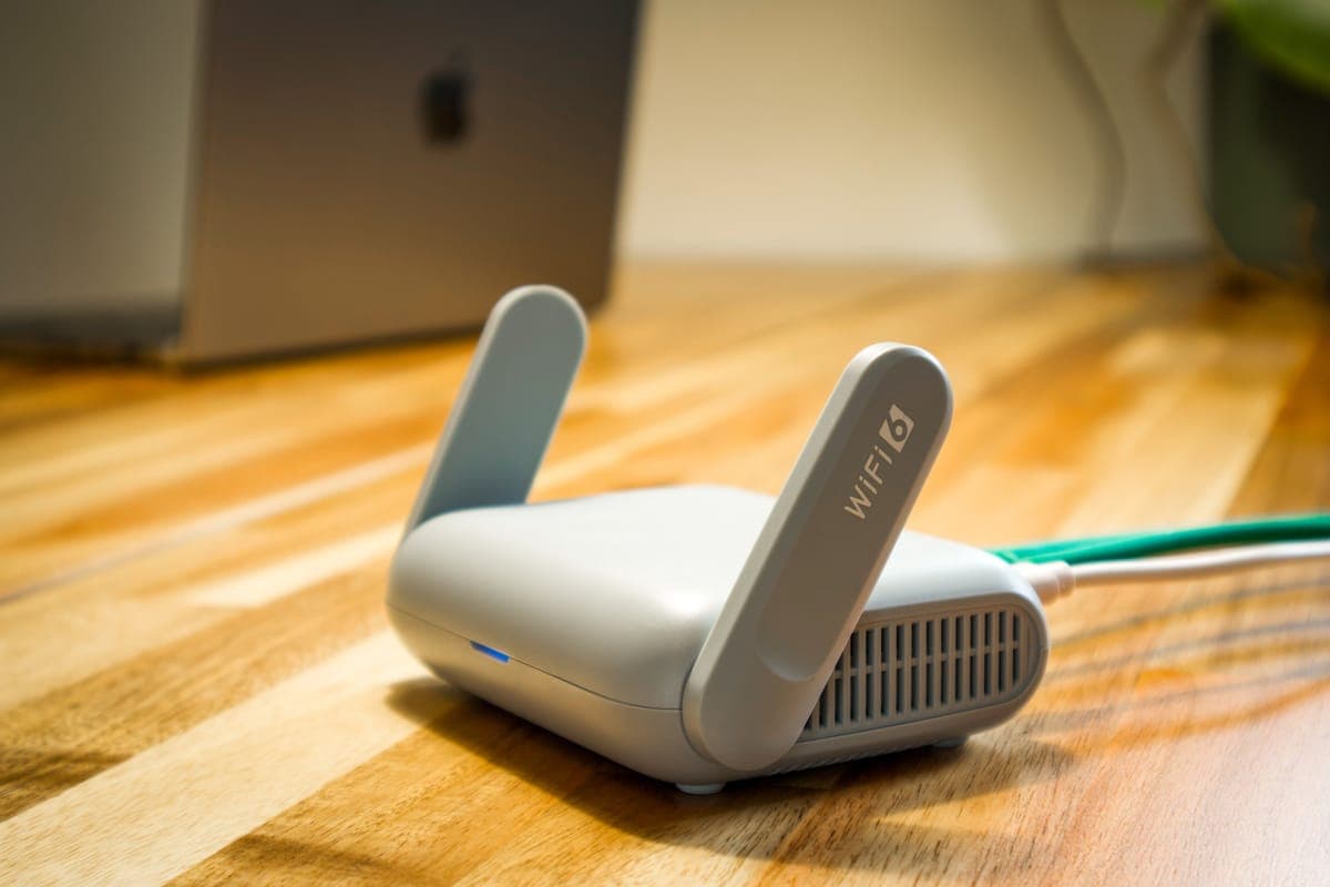 A home wifi router with antennas on a wooden desk