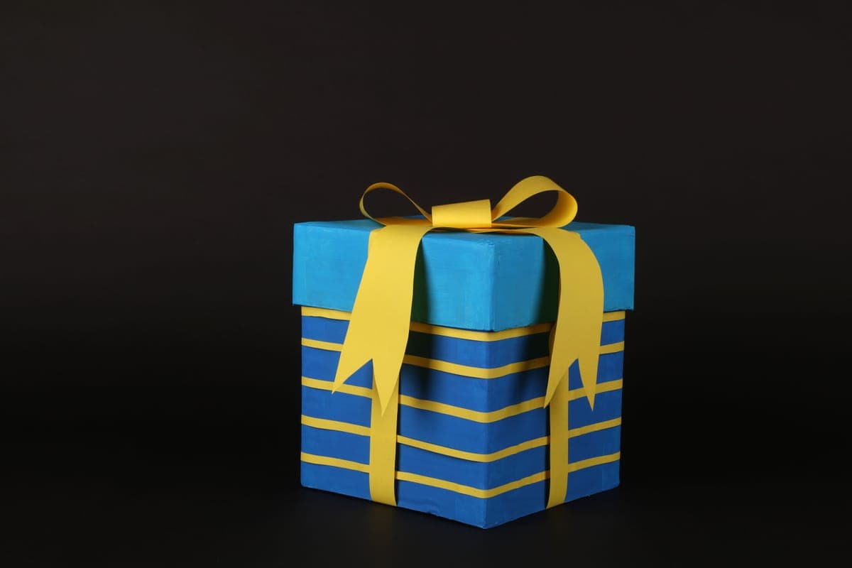 A gift box wrapped in blue paper with a ribbon