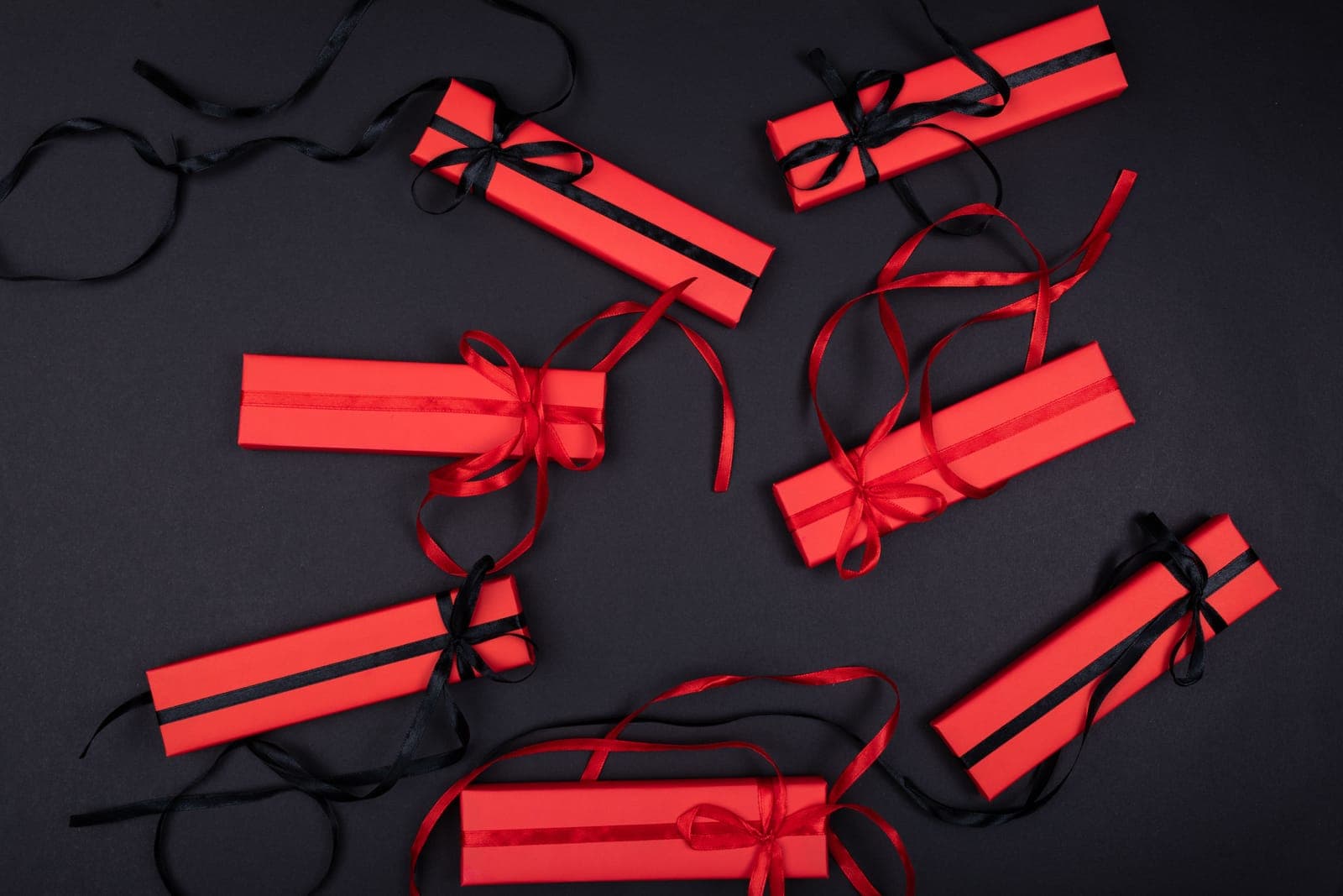 Wrapped gift boxes with ribbons arranged on a dark surface
