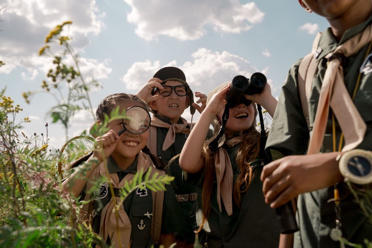 A group of children exploring outdoors with binoculars